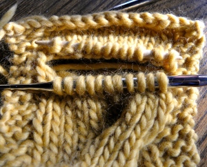 pullout the cabled stitches, place on needles and re-knit properly